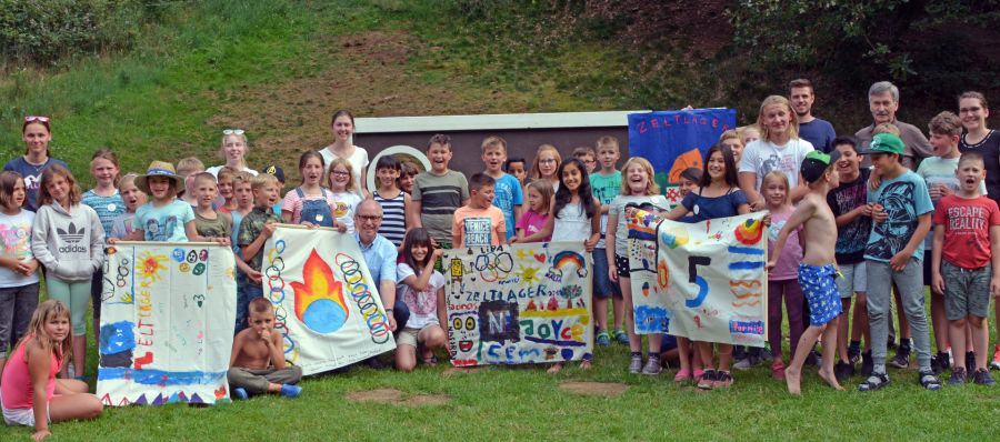 Jede Gruppe hat ihre eigene Fahne gemalt – Landrat Manfred Müller (vorn im Bild in der ersten Reihe) besuchte auch in diesem Sommer das Kreis-Zeltlager    Bildrechte: Kreis Paderborn, Amt für Presse- und Öffentlichkeitsarbeit, Meike Delang